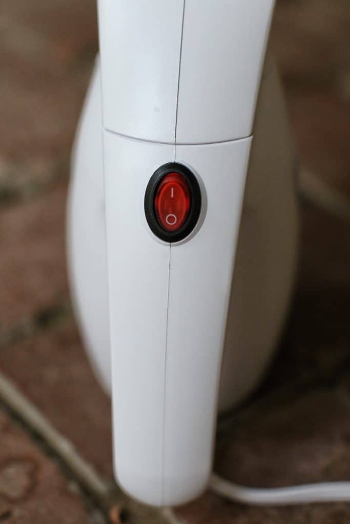 A close up showing the handle, dial, and on off switch of a portable steamer